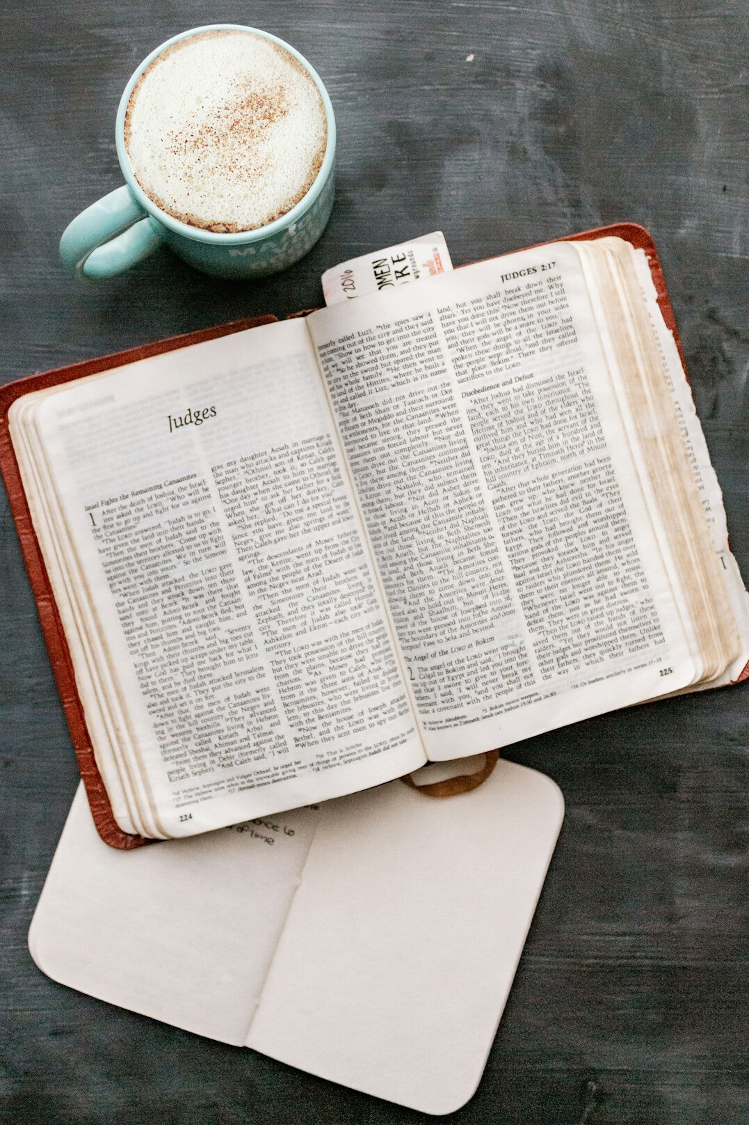 Open notebook with handwritten notes and a cup of coffee